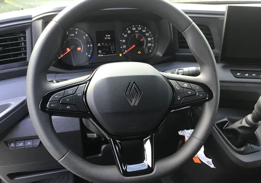 Vue rapprochée du volant multifonction noir du Renault Master 2025 avec tableau de bord et levier de vitesse manuel.