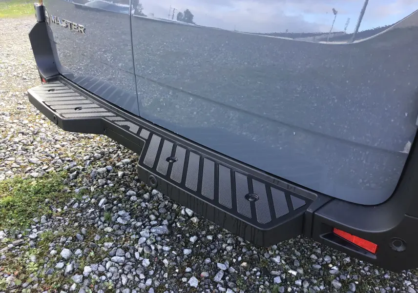 Vue rapprochée du marchepied arrière noir sur la partie droite d’un Renault Master gris urbain.
