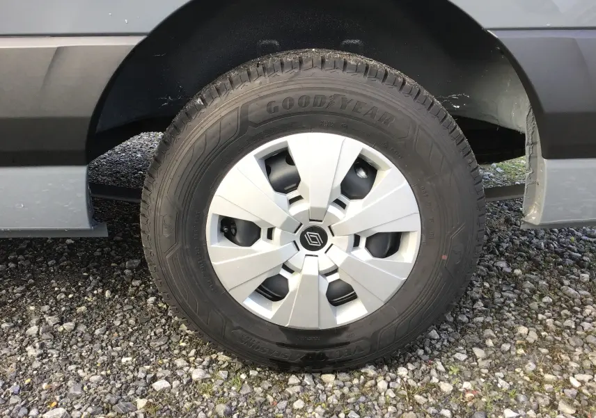 Gros plan sur la roue avant droite du Renault Master gris urbain, avec pneu Goodyear tout-temps et jante argentée.