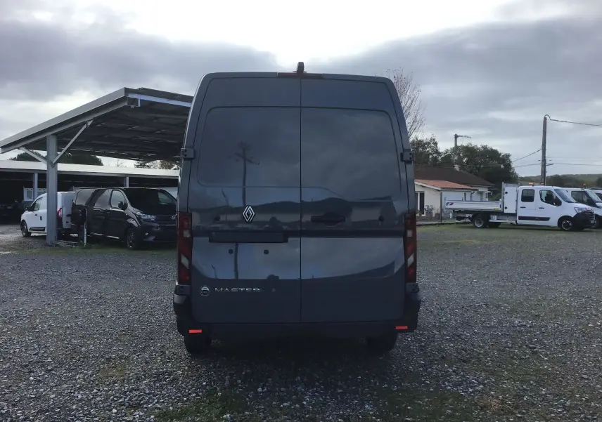 Vue arrière d’un Renault Master gris urbain 2025, avec portes arrière fermées et logo visible au centre.