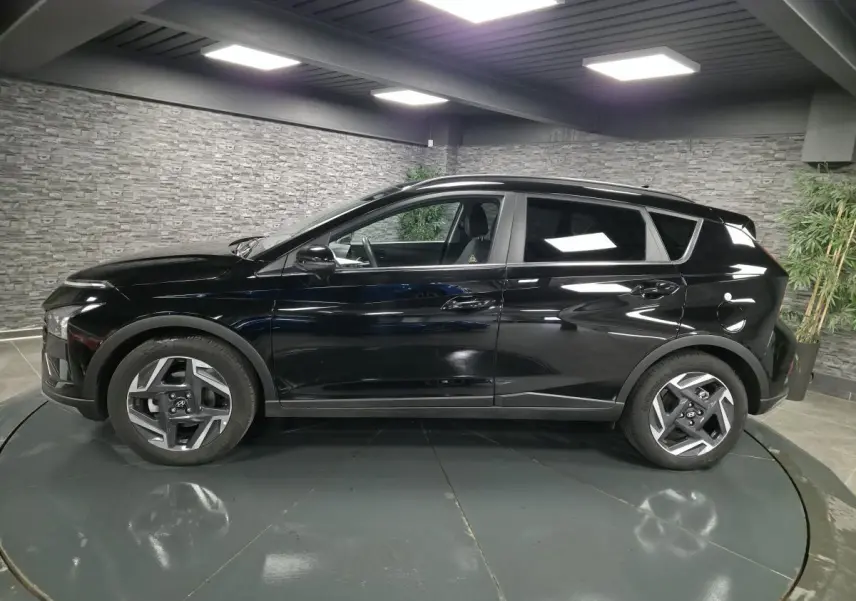 Profil côté gauche d'un Hyundai Bayon noir 2025 avec jantes alliage 17 pouces et vitres surteintées.