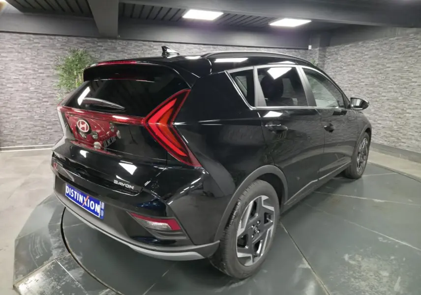 Vue 3/4 arrière droite d'une Hyundai Bayon noire avec feux arrière en forme de flèche et jantes alliage 17 pouces.