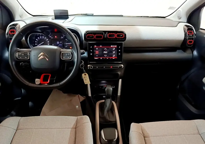 Vue intérieure avant du Citroën C3 Aircross 2020 avec tableau de bord noir et beige et touches rouges sur aérateurs.