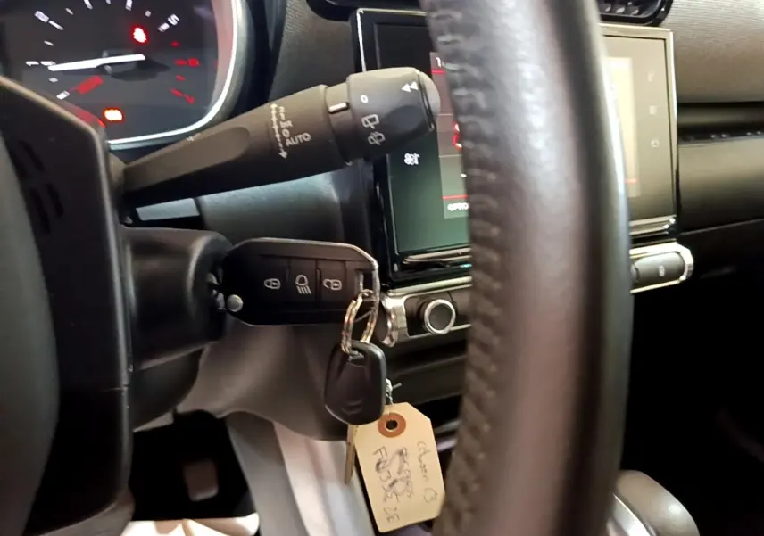 Vue rapprochée du tableau de bord côté conducteur d'une Citroën C3 Aircross 2020, clé insérée et volant cuir visible.