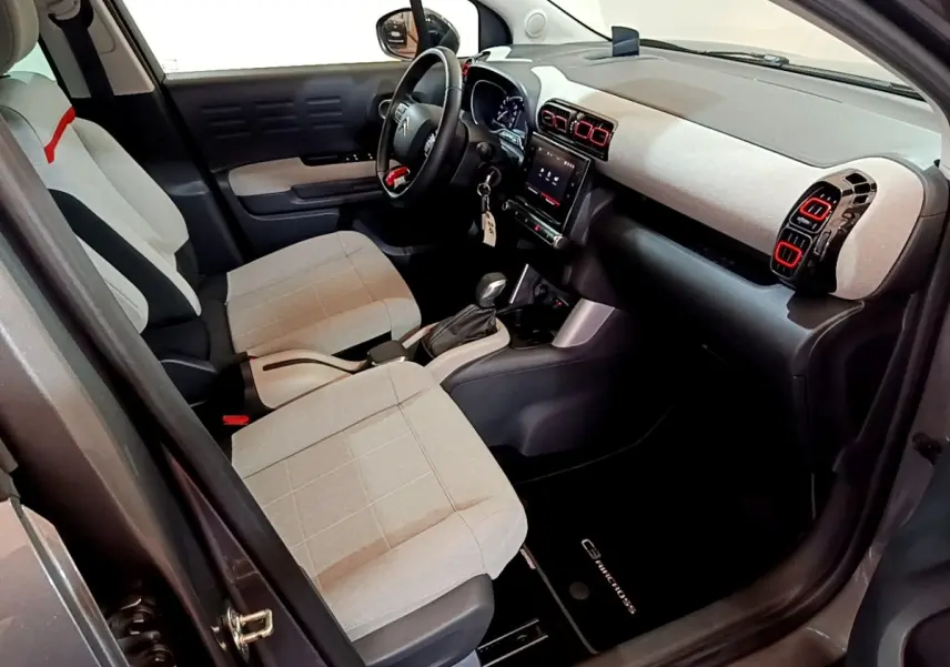 Intérieur avant droit du Citroën C3 Aircross 2020 avec sièges gris clair et tableau de bord clair aux aérateurs rouges.