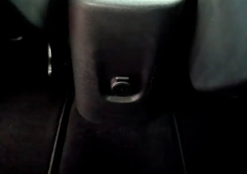 Prise 12V noire sous la console centrale arrière du Citroën C3 Aircross 2020, intérieur sombre.