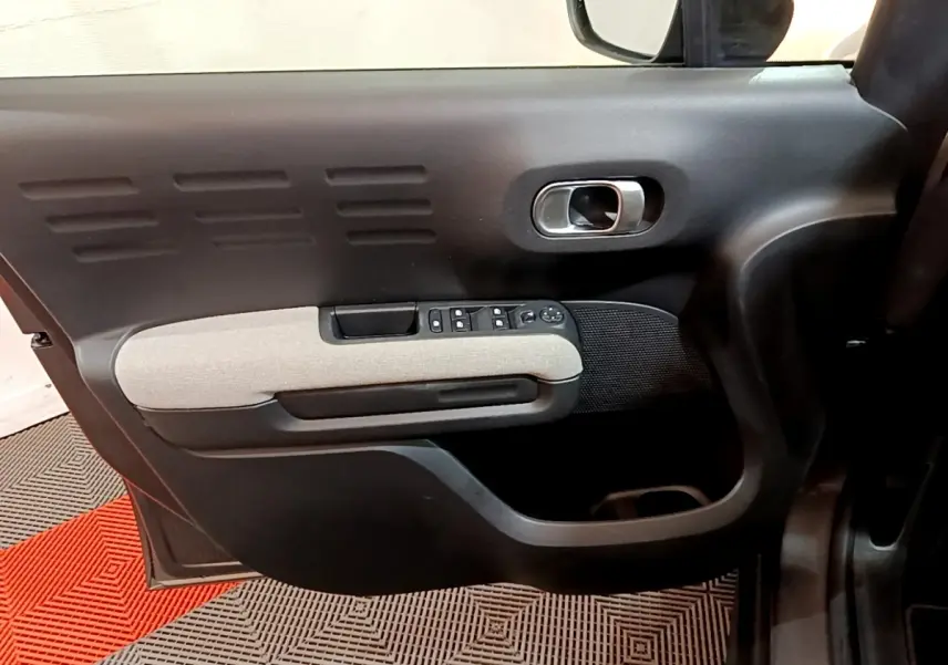 Porte intérieure côté gauche de Citroën C3 Aircross 2020, avec accoudoir gris clair et commandes électriques.