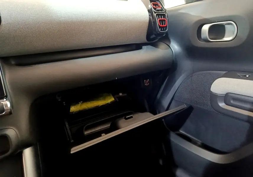 Intérieur du Citroën C3 Aircross 2020, vue côté passager sur la boîte à gants ouverte avec détails gris et noirs.