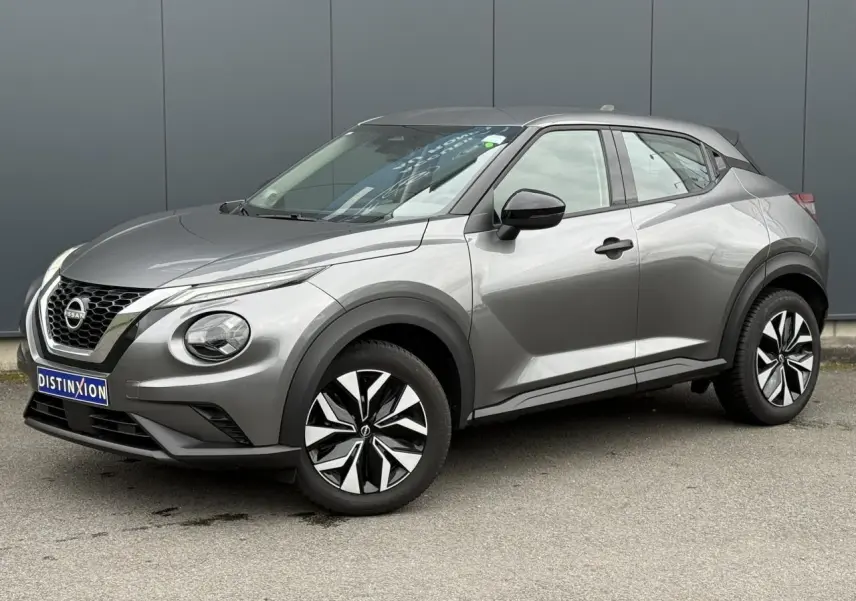Nissan Juke 2025 gris foncé en vue 3/4 avant droit, avec jantes alliage et calandre distinctive chromée.