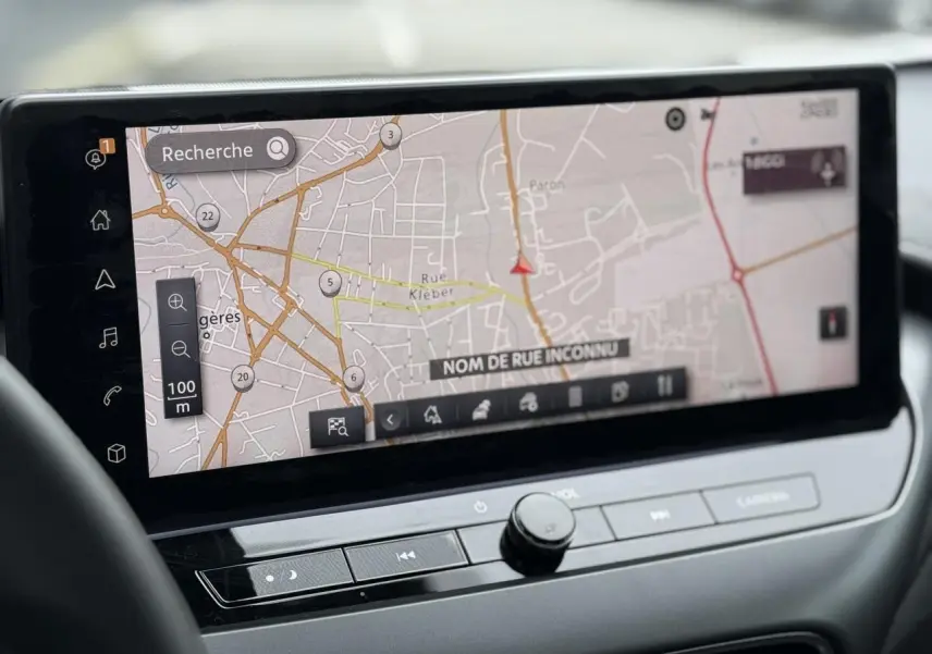 Vue rapprochée de l’écran tactile GPS couleur du tableau de bord du Nissan Juke 2025, avec commandes intégrées.