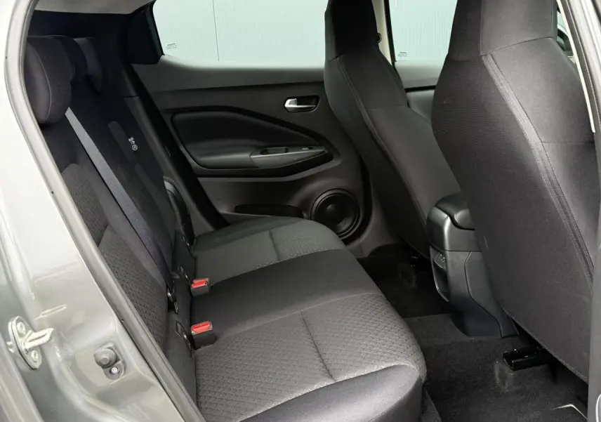 Vue intérieure côté gauche sur la banquette arrière et les sièges avant du Nissan Juke gris foncé 2025.