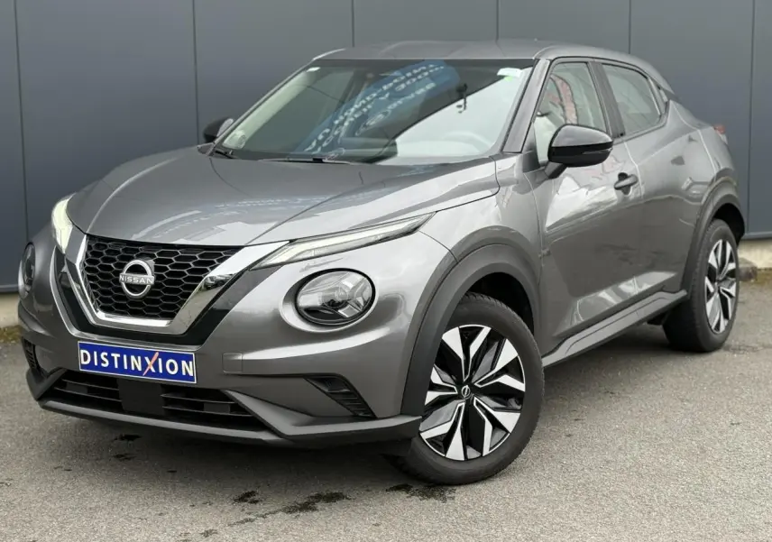 Nissan Juke gris foncé en vue 3/4 avant droit, mettant en valeur sa calandre V-Motion et ses phares LED distinctifs.