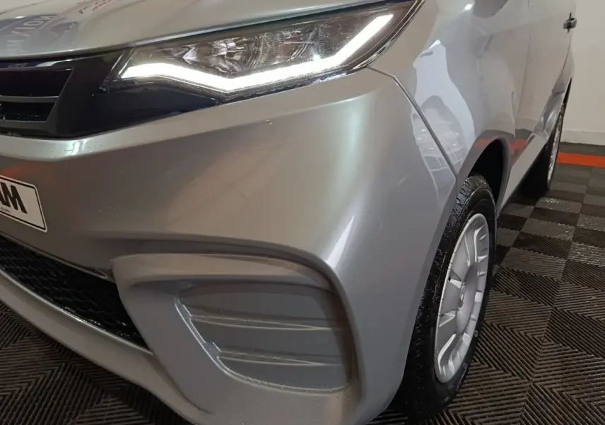 Vue 3/4 avant droit d'une Aixam Ambition 0.5 City Pack gris clair avec phares LED et jantes spécifiques.