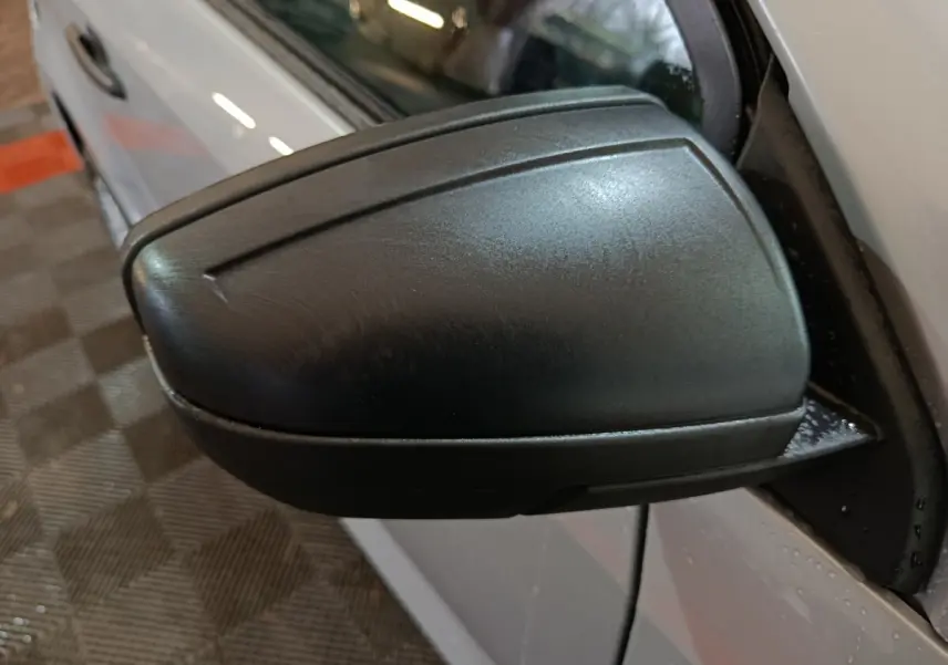 Gros plan sur le rétroviseur caméra côté conducteur d'une Aixam Ambition 0.5 City Pack gris clair, vue latérale gauche.