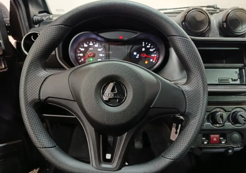 Vue rapprochée du volant noir de l'AIXAM AMBITION 0.5 CITY PACK 2026 avec tableau de bord et commandes visibles.