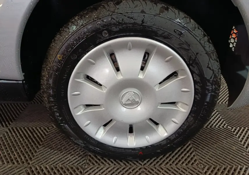 Gros plan sur la roue avant droite avec enjoliveur gris clair de l'AIXAM AMBITION 0.5 CITY PACK 2026.