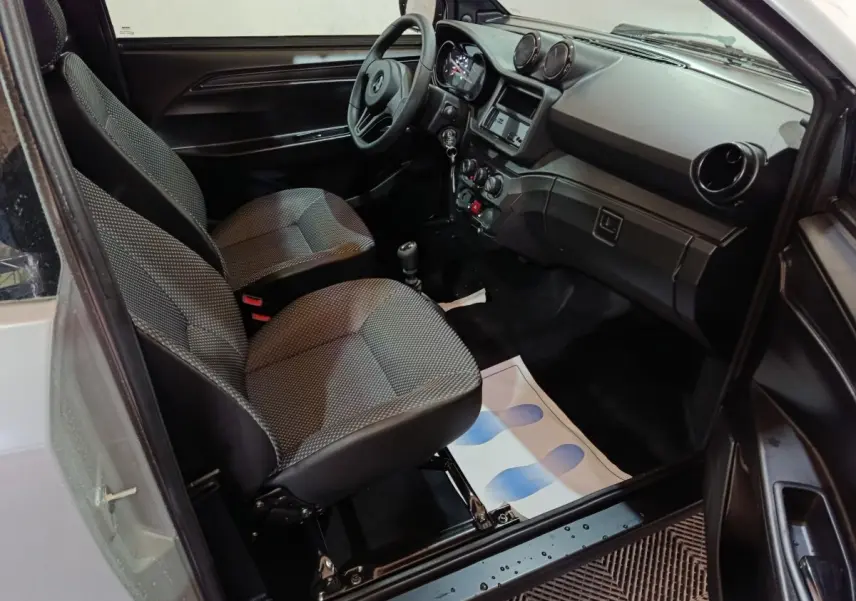 Vue intérieure côté conducteur de l'AIXAM AMBITION 0.5 CITY PACK 2026, sièges gris et tableau de bord noir.