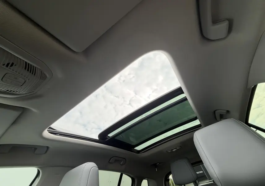 Vue intérieure du toit ouvrant panoramique vitré du Citroën C5 Aircross gris métal 2024, avec sièges avant visibles.