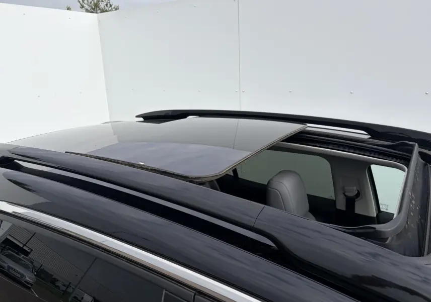 Toit ouvrant panoramique ouvert vu de dessus sur un Citroën C5 Aircross gris métal avec barres de toit noir brillant.