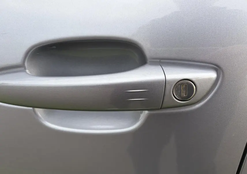 Poignée de porte gris métal en gros plan sur le côté gauche d'une Citroën C5 Aircross 2024 hybride.