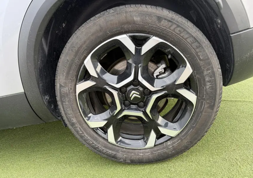 Gros plan sur la jante alliage 18'' bi-ton noir et argent du côté gauche d'un Citroën C5 Aircross gris métal.