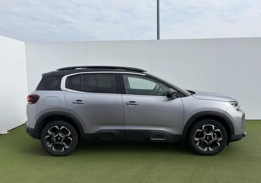 Profil droit du Citroën C5 Aircross gris métal 2024 avec toit noir et jantes alliage bi-ton distinctives.