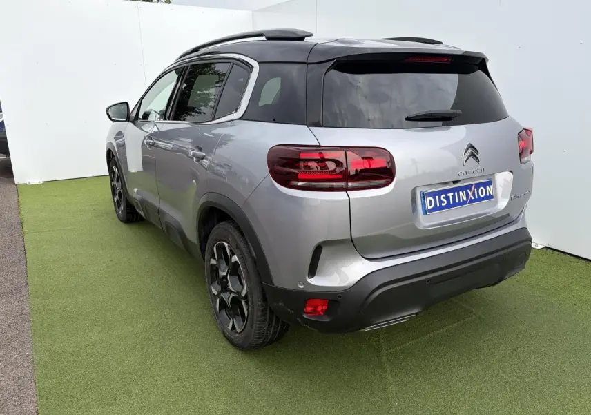 Vue 3/4 arrière droit d'un Citroën C5 Aircross gris métal avec toit noir et jantes bi-ton 18 pouces.