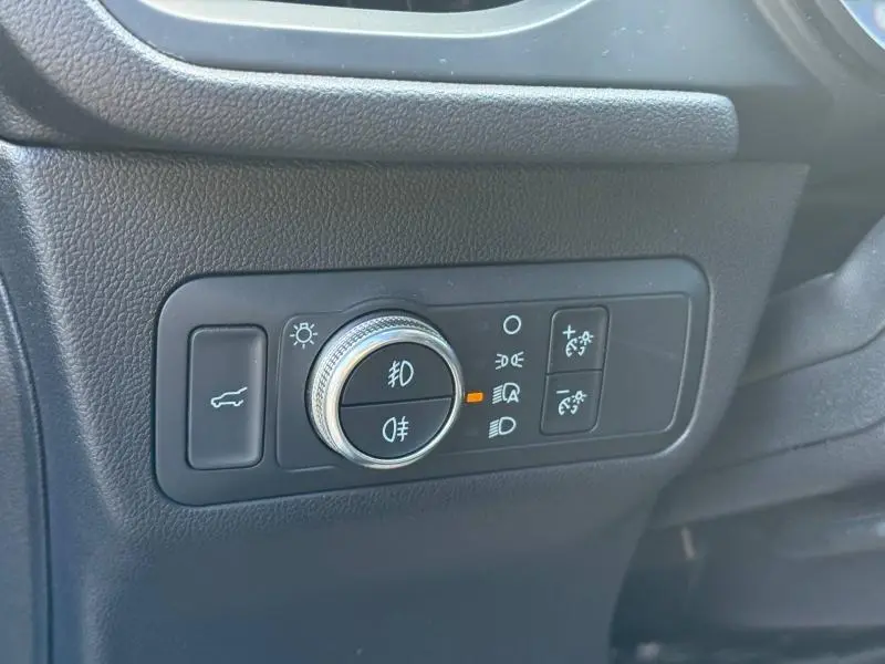 Gros plan sur le panneau de commande des éclairages intérieurs noirs du Ford Kuga 2023, côté gauche du tableau de bord.