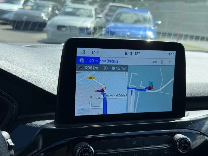 Écran tactile GPS du Ford Kuga 2023 en vue intérieure, affichant la navigation avec luminosité naturelle.