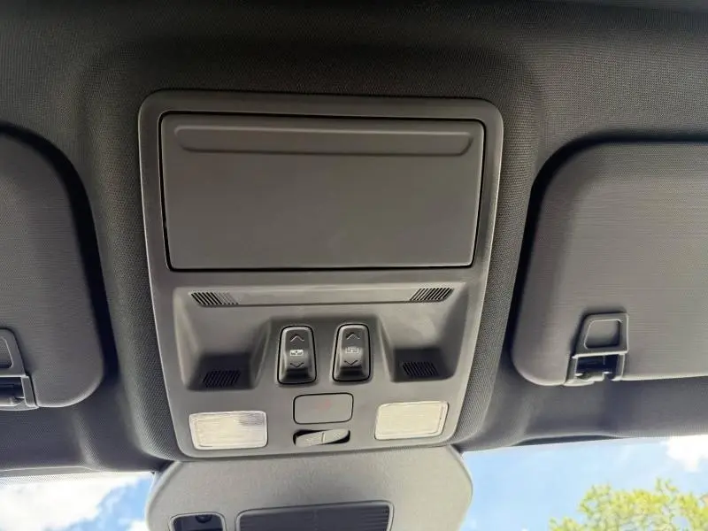 Vue intérieure du plafonnier noir avec commandes d'ouverture de toit et éclairages dans un Ford Kuga 2023 noir Agate Métallisée.