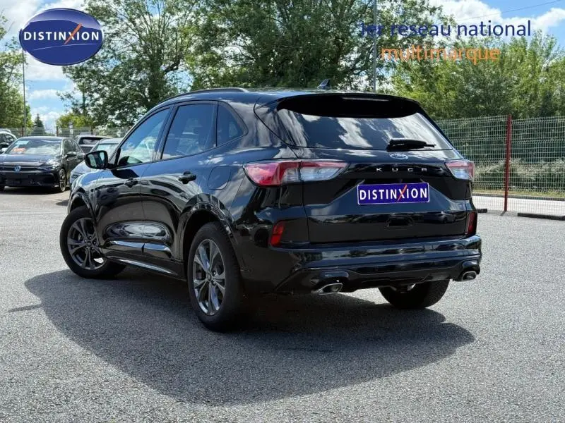 Vue 3/4 arrière droite d'un Ford Kuga noir Agate Métallisée avec double sortie d'échappement et feux LED arrière.