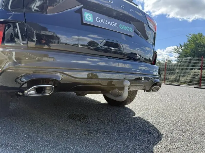 Vue rapprochée arrière droite du Ford Kuga noir Agate Métallisée, mettant en valeur la double sortie d’échappement et l’attelage.
