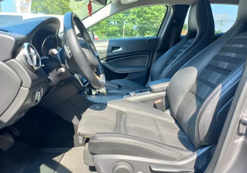 Intérieur de la Mercedes GLA 2019 en gris, vue côté conducteur montrant sièges sport et volant cuir perforé.