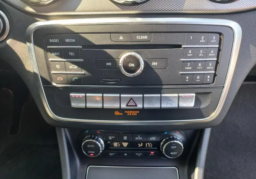 Vue rapprochée du tableau de bord de la Mercedes GLA 2019 gris, montrant la console centrale avec commandes multimédia et climatisation.