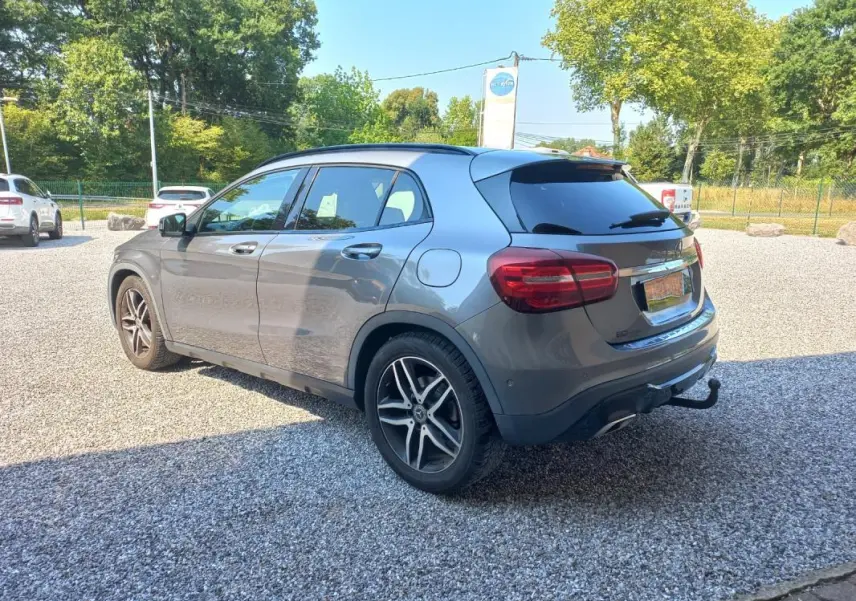 Mercedes GLA 2019 gris en 3/4 arrière droit, avec jantes alliage et attelage visible sur parking extérieur.