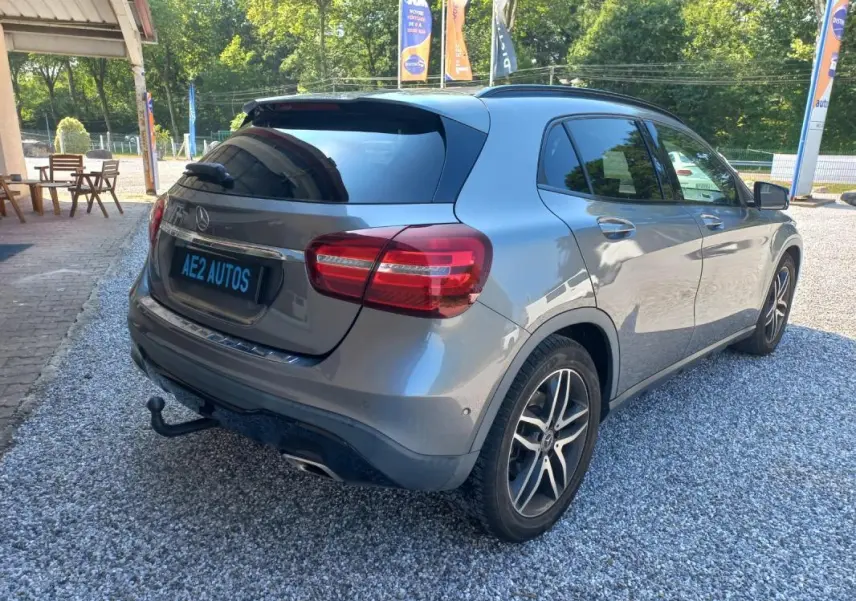 Mercedes GLA gris en 3/4 arrière droit, avec attelage et jantes alliage, stationné sur gravier en extérieur.