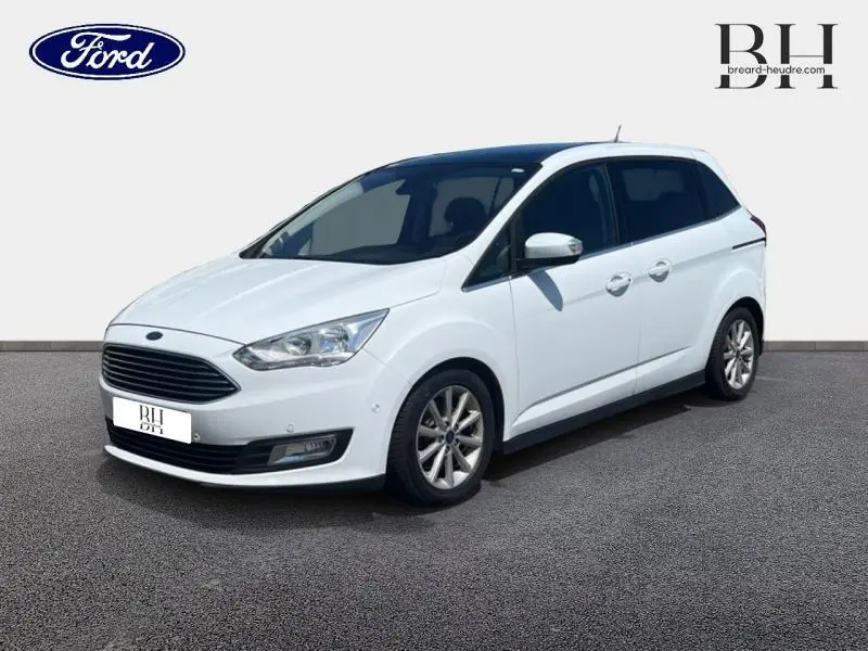 Ford Grand C-Max blanc glacier en vue 3/4 avant droit, avec vitres arrière surteintées et jantes alu.