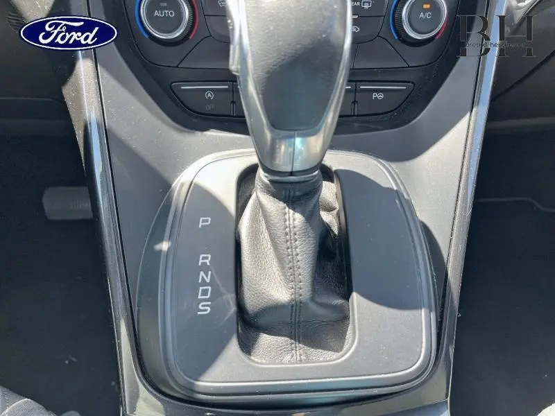 Gros plan sur le levier de vitesses automatique noir de la Ford Grand C-Max, entouré de commandes de climatisation.