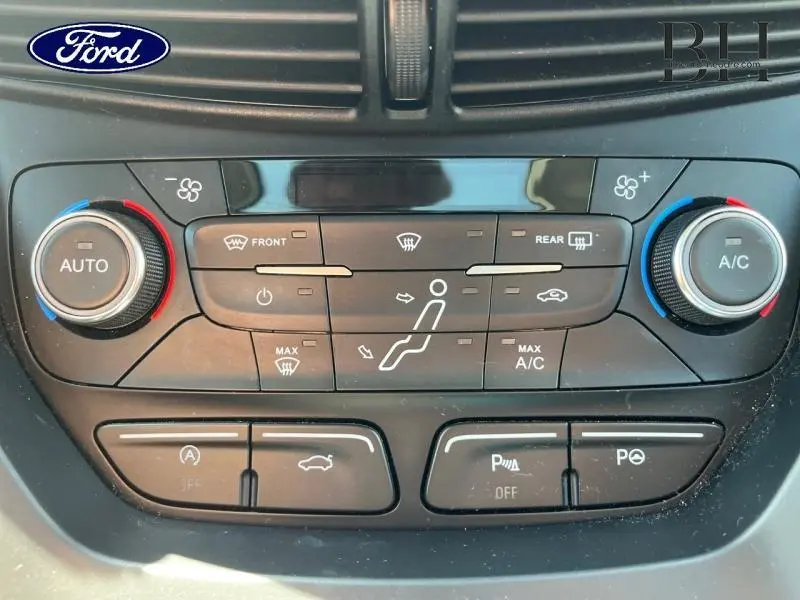 Vue rapprochée du tableau de bord du Ford Grand C-Max 2017 montrant les commandes de climatisation et d’aide au stationnement.