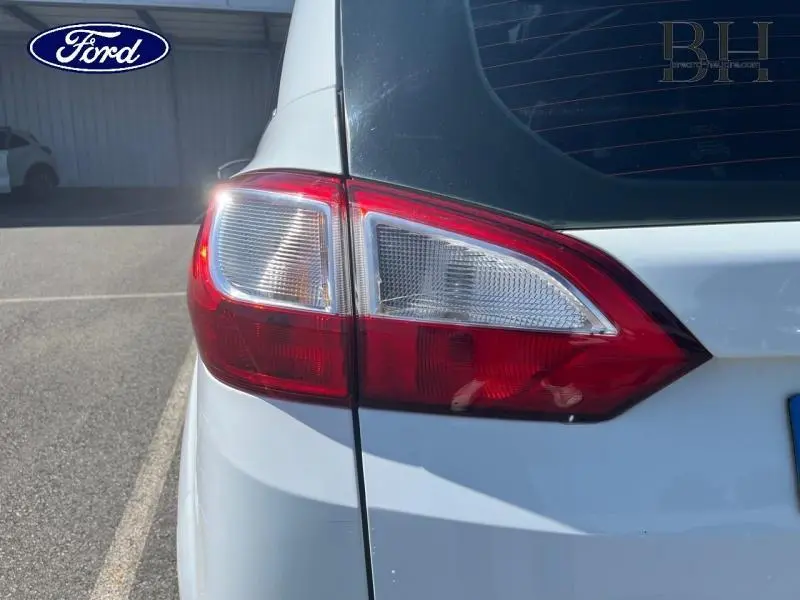 Gros plan sur le feu arrière droit du Ford Grand C-MAX blanc Glacier, avec lunette arrière teintée visible.
