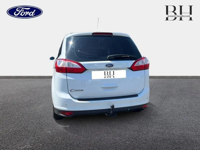 Vue arrière d'un Ford Grand C-Max blanc Glacier de 2017 avec attelage fixe et vitres arrière surteintées.