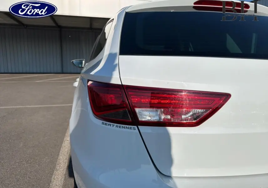Gros plan sur l'arrière droit blanc candy d'une SEAT LEON ST avec feu arrière et logo SEAT Rennes visible.