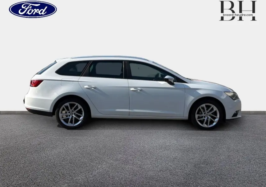 Profil côté gauche d'une SEAT LEON ST blanche Candy de 2017 avec jantes alliage et vitres teintées.