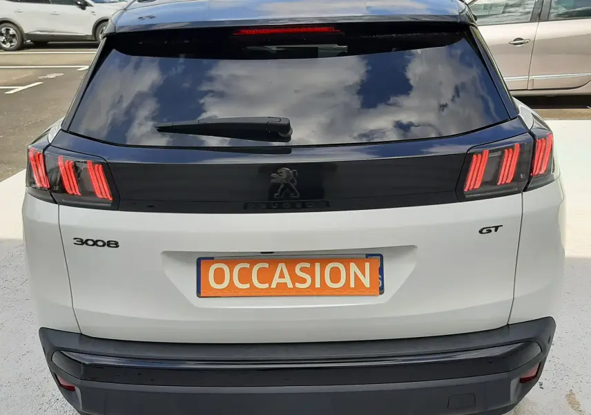 Vue arrière d'un Peugeot 3008 GT blanc nacré avec toit noir, feux arrière LED distinctifs et plaque "OCCASION".
