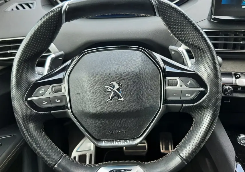 Vue rapprochée du volant cuir perforé noir avec logo Peugeot et badge GT du Peugeot 3008 1.5 BlueHDi 2022.