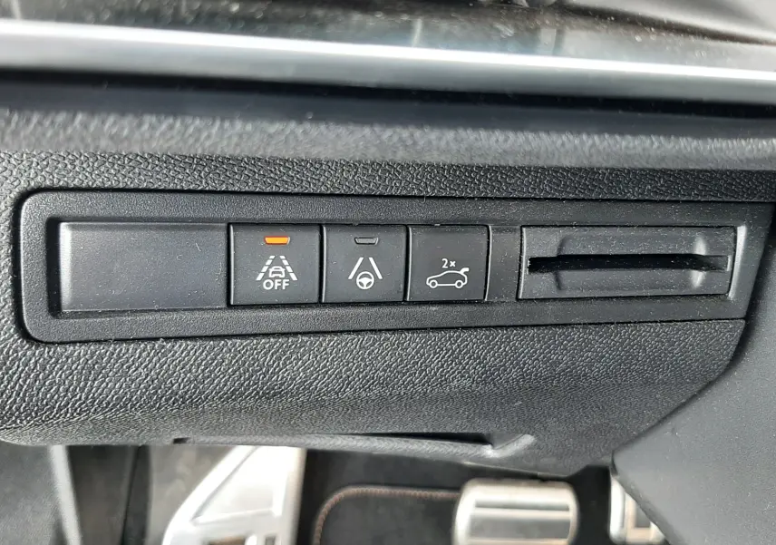 Gros plan sur les boutons de commande du tableau de bord du Peugeot 3008 blanc nacré, avec témoin orange activé.