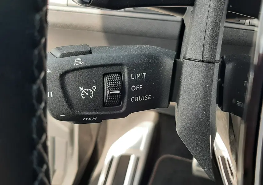 Gros plan sur la commande de régulateur de vitesse à gauche du volant du Peugeot 3008 blanc nacré 2022.