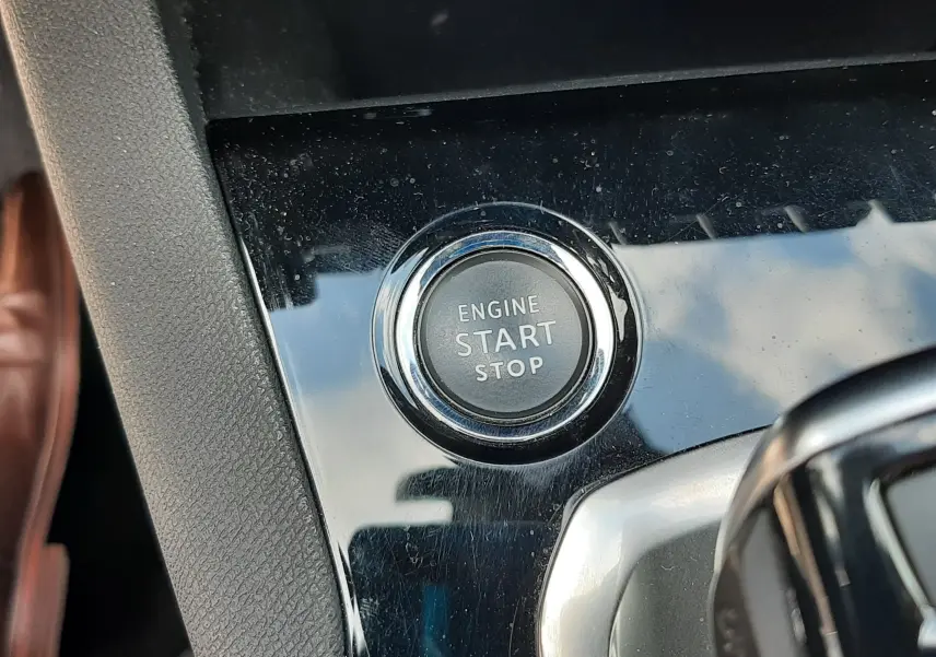 Gros plan sur le bouton moteur start/stop dans l’habitacle noir brillant du Peugeot 3008 blanc nacré toit noir.