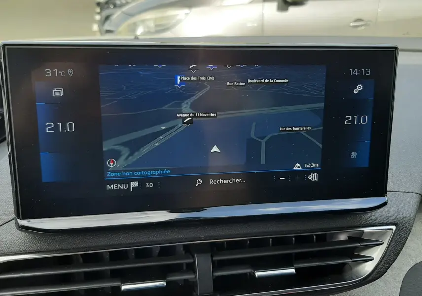 Vue intérieure du tableau de bord du Peugeot 3008 2022, écran tactile affichant la navigation et la climatisation à 21°C.