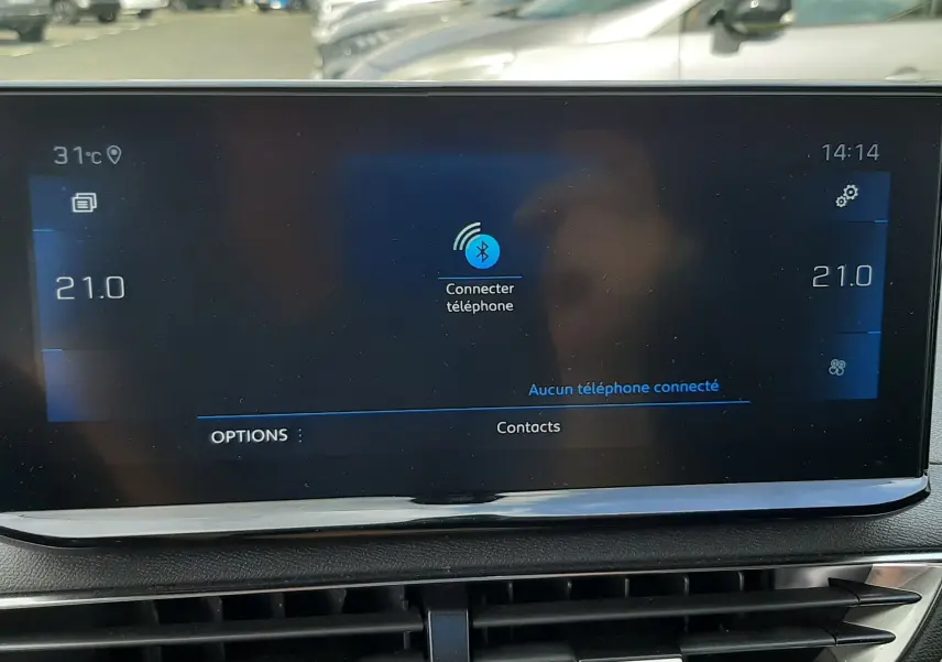 Écran tactile central du Peugeot 3008 blanc nacré, affichant la connexion Bluetooth, avec tableau de bord noir visible.